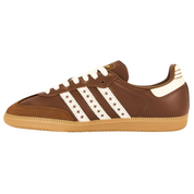 Brown Adidas sneaker with white stripes on a white background