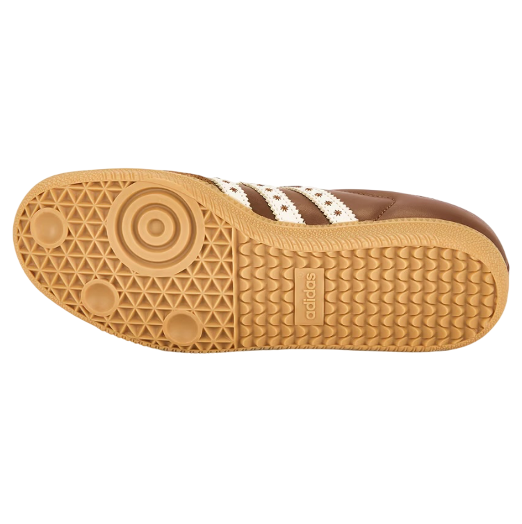 Close-up of a brown sneaker sole with white stripes on a white background