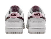White Nike sneakers with pink swoosh logo on a white background