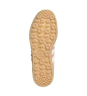Close-up of a shoe sole with a brand logo on a light gray background