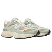 Pair of light gray sneakers with beige accents on a white background